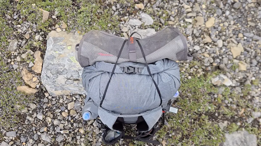 The V-shaped top strap holds a foam pad or a bear canister on top of the pack.
