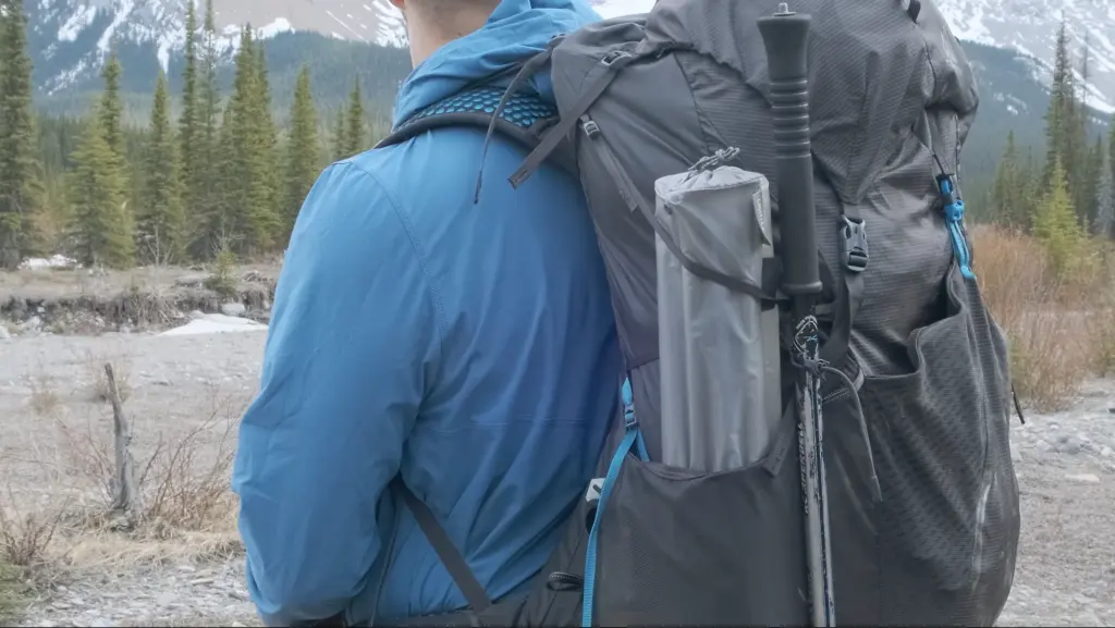 The side pockets fit tent poles, and both trekking poles go into the same loop.